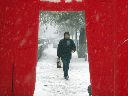 12月3日，在吉林省吉林市街头，行人冒雪出行。