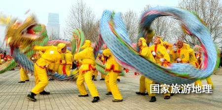  在郑州市举办的一个元宵节舞龙大赛上，一支舞龙队在表演高难度动作（2011年2月16日摄）。元宵节，除了观赏花灯外，最热闹的活动当属传统民俗表演。在中原地区，从正月十三开始，各地都要连续数日举办各种大型文艺表演活动。